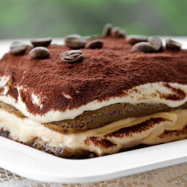 Authentieke Italiaanse tiramisu met cacaopoeder en koffiebonen op een bord, L'ARCO Food & Wine
